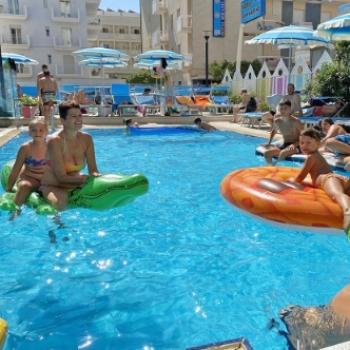 People enjoying the pool with colorful inflatables.