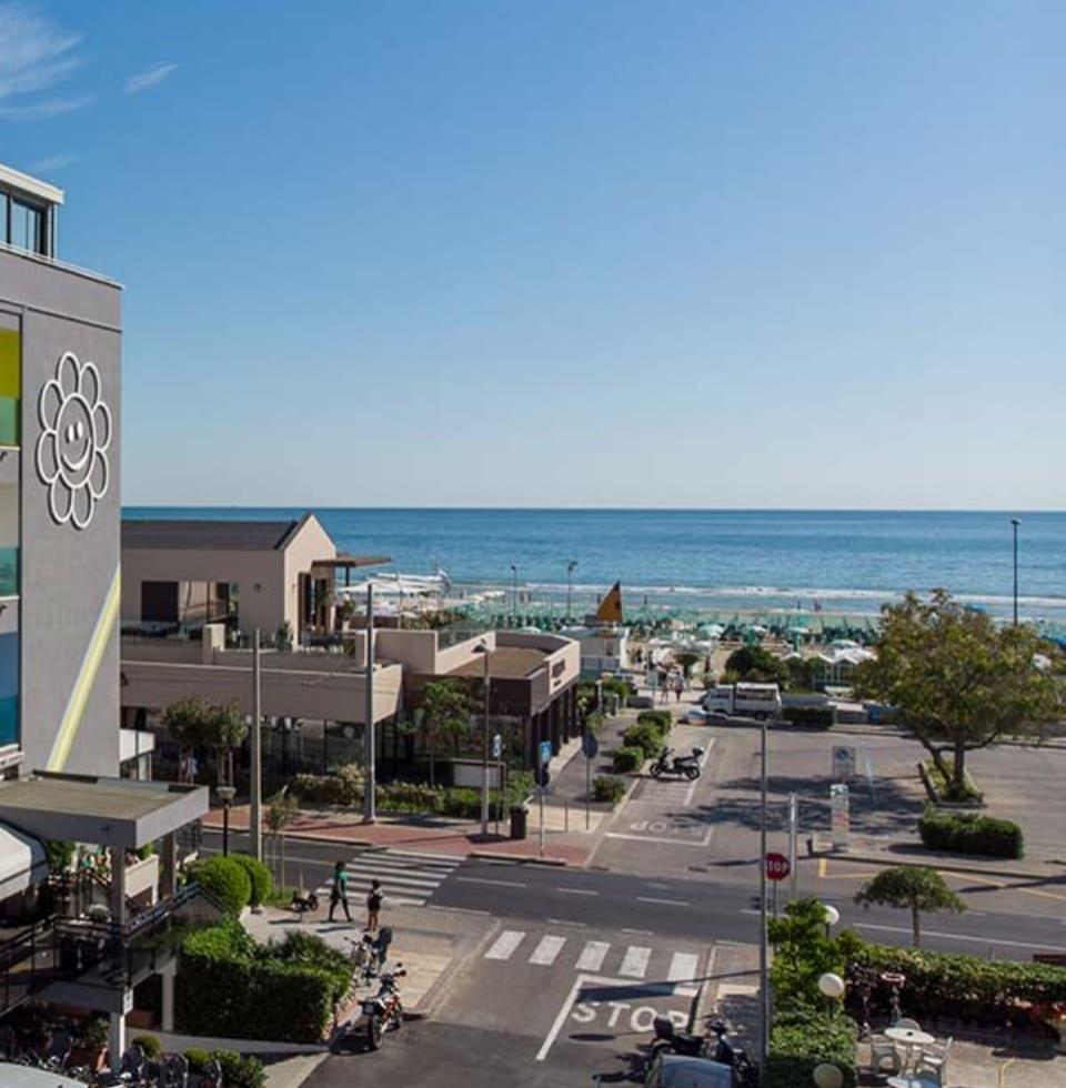 Vista sul mare con edifici moderni e spiaggia attrezzata.